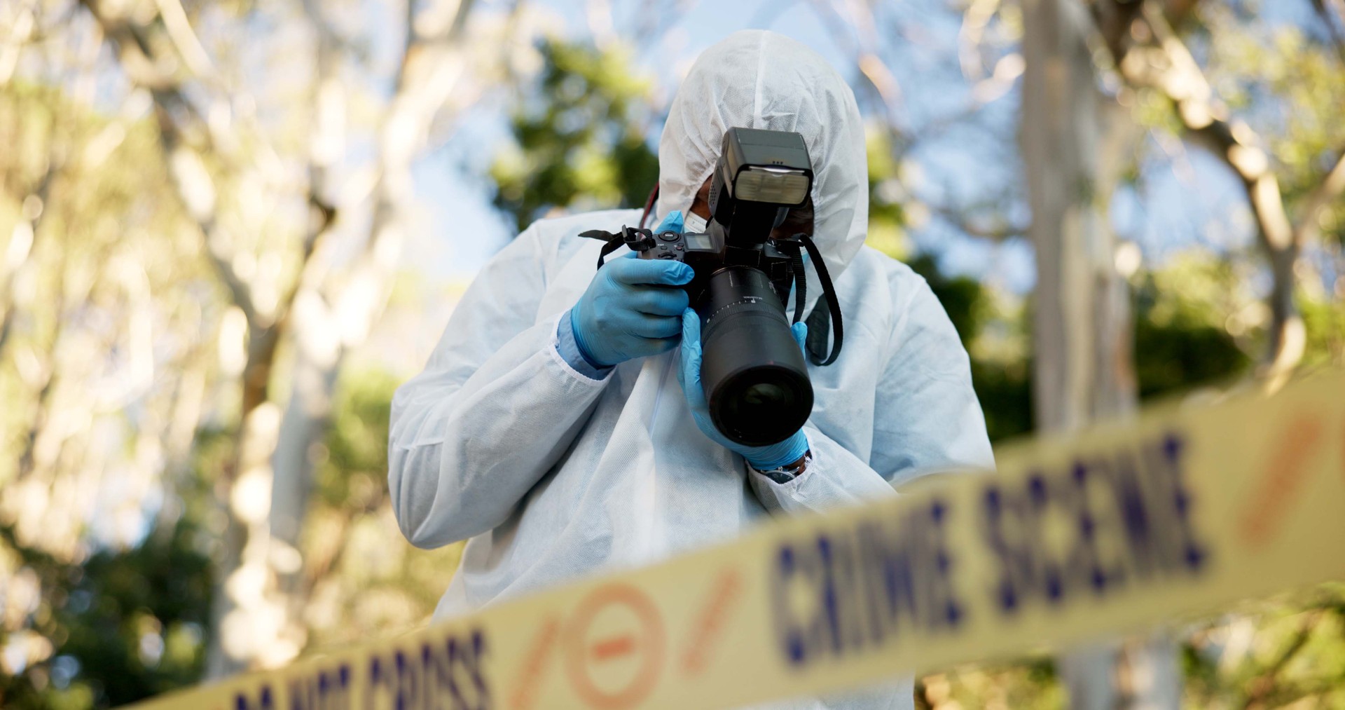 Csi, photographer and police tape at crime scene for investigation in forest with evidence and safety hazmat.
Forensic quarantine, expert investigator and pictures for observation and case research